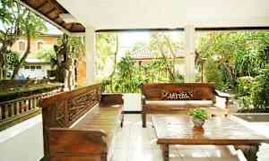 Udendørsterrasse med to træbænke og et sofabord, omgivet af frodig have. (AI-genereret tekst)