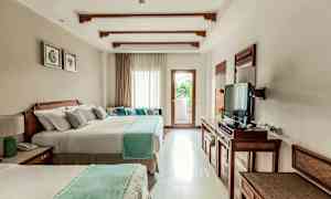 Et hotelværelse med to store senge, et fjernsyn og et vindue med lysindfald og en altan. (AI-genereret tekst)