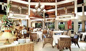 Restaurant med rottingmøbler og hvide duge. (AI-genereret tekst)