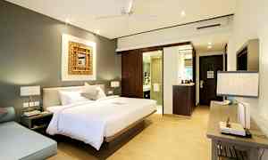 Et soveværelse med en stor seng, en siddegruppe og et badeværelse i baggrunden. (AI-genereret tekst)