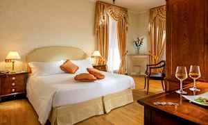 Et elegant hotelværelse med dobbeltseng, dekorerede puder og træinteriør. (AI-genereret tekst)