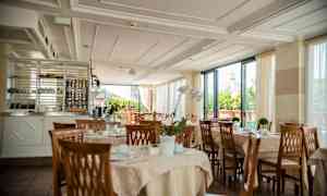 En restaurant med dækkede borde og udsigt til en bygning med kuppel. (AI-genereret tekst)