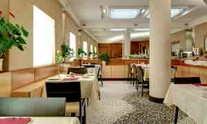 En moderne restaurant med opsatte borde og blomster på hvert bord. (AI-genereret tekst)