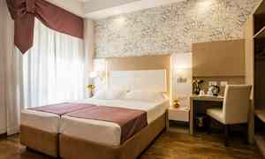 Et hotelværelse med en dobbeltseng, skrivebord og stol samt dekorative detaljer. (AI-genereret tekst)