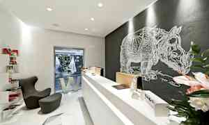 Et moderne kontor med minimalistisk design, reception og et vægmaleri af en næsehorn. (AI-genereret tekst)