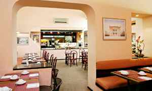 Et restaurantområde med borde og stole samt et buffetserveringsområde. (AI-genereret tekst)