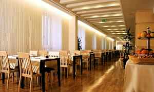 Billede af en restaurant med borde og stole, trægulv og frugt på et bord. (AI-genereret tekst)