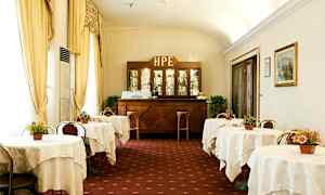 Billede af en klassisk hotelcafé med dækkede borde og en træbar i baggrunden. (AI-genereret tekst)