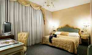 Et hotelværelse med en dobbeltseng, et skrivebord med stol og et fjernsyn. (AI-genereret tekst)