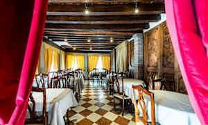 Interiør af restaurant med dækkede borde og træstole. (AI-genereret tekst)