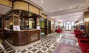 Reception og lobbyområde med marmorgulv og røde sofaer. (AI-genereret tekst)