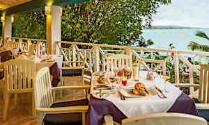 Et dækket bord på en terrasse med udsigt over havet. (AI-genereret tekst)