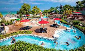 Poolområde med børn, der leger, samt personer, der svømmer i en omkringliggende strømmet pool. (AI-genereret tekst)