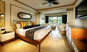 Et hotelværelse med en dobbeltseng, indbydende siddeområde og balkon med udsigt. (AI-genereret tekst)