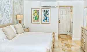 Et lyst og stilfuldt soveværelse med en dobbeltseng, vægkunst og en dør. (AI-genereret tekst)