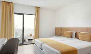 Hotelværelse med to enkeltsenge og altan. (AI-genereret tekst)