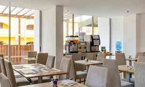 Spisesal med dækkede borde og drikkeautomater. (AI-genereret tekst)