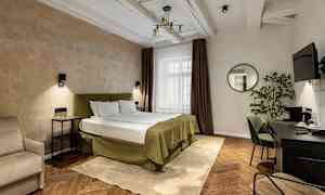 Et hotelværelse med en dobbeltseng, natborde, en skrivebordsplads og et spejl på væggen. (AI-genereret tekst)