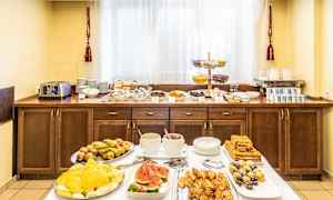 Hotelmorgenmadsbuffet med forskellige retter, herunder frugt, bagværk og drikkevarer. (AI-genereret tekst)