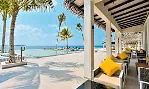 En udendørs terrasse med siddepladser og en pool med udsigt over havet. (AI-genereret tekst)