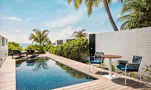 Privat pool på en terrasse med solsenge og havudsigt. (AI-genereret tekst)