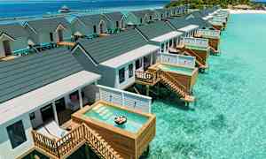 Bungalows på pæle med private små pools over klart turkisblåt vand. (AI-genereret tekst)