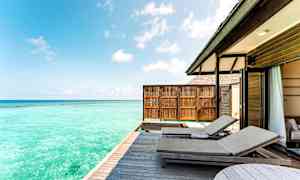 Udendørs terrasse med solsenge og en blå havudsigt. (AI-genereret tekst)