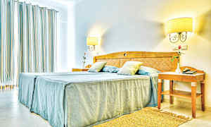 Billede af et lyst hotelværelse med en dobbeltseng og natbord. (AI-genereret tekst)