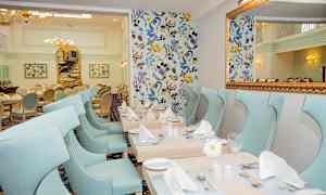 En elegant spisestue med lyseblå stole og dekorerede borde. (AI-genereret tekst)