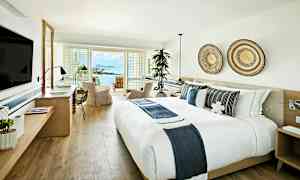 Et lyst og moderne hotelværelse med udsigt over havet. (AI-genereret tekst)