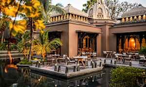 En udendørs scene med borde og stole ved en bygning med kuppelformet tag. (AI-genereret tekst)