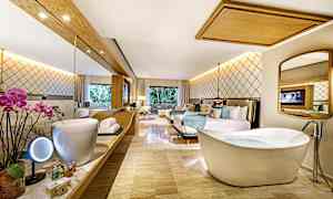 Et hotelværelse med moderne møbler, fritstående badekar og spejl. (AI-genereret tekst)