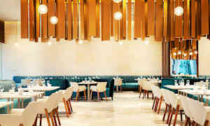 En moderne restaurant med elegante stole og borde. Dekorative lys hænger fra loftet. (AI-genereret tekst)