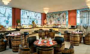 Et restaurantområde med lågstole og borde, omgivet af en buffet og dekorerede gardiner. (AI-genereret tekst)