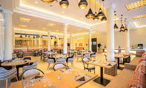 Restaurant med dækkede borde og hængende loftslamper. (AI-genereret tekst)