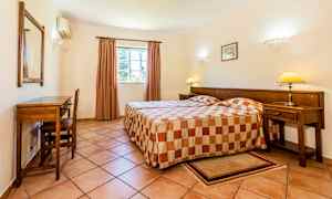 Et hotelværelse med to enkeltsenge og et skrivebord ved væggen. (AI-genereret tekst)