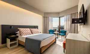 Moderne hotelværelse med dobbeltseng, siddeområde og udsigt. (AI-genereret tekst)