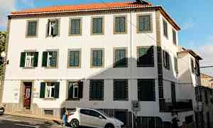 Bygning med hvide vægge, grønne skodder og rødt tagsten. (AI-genereret tekst)