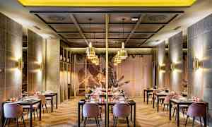 Billede af en elegant restaurant med borde og stole, moderne indretning og stemningsfuld belysning. (AI-genereret tekst)