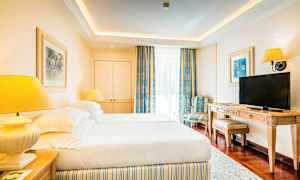 Et hotelværelse med to senge, et TV og en stol. (AI-genereret tekst)