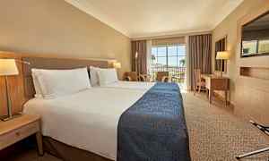 Hotelværelse med to enkeltsenge og en balkon med udsigt. (AI-genereret tekst)