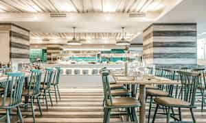 Billede af en moderne restaurant med dækkede borde og en buffet i baggrunden. (AI-genereret tekst)