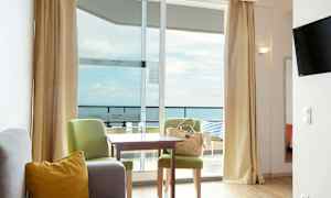 Et hotelværelse med siddegruppe og udsigt over havet. (AI-genereret tekst)