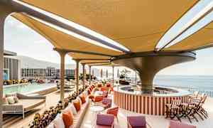 Moderne poolområde med skyggefuldt tag, liggestole og udsigt over havet. (AI-genereret tekst)