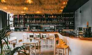 En moderne bar med højt til loftet og elegant indretning. (AI-genereret tekst)