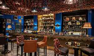 Interiør af en elegant bar med siddepladser og dekoreret loft. (AI-genereret tekst)