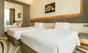 Hotelværelse med to enkeltsenge, moderne indretning og lyse farver. (AI-genereret tekst)