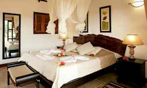 Hotelværelse med dobbeltseng, dekoreret med blomster og håndklæder. (AI-genereret tekst)