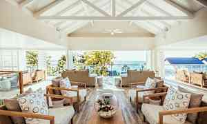 Loungeområde med komfortable siddegrupper og en udsigt over havet udenfor. (AI-genereret tekst)