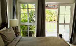 Et soveværelse med vindue og dør, der vender ud mod en have. (AI-genereret tekst)